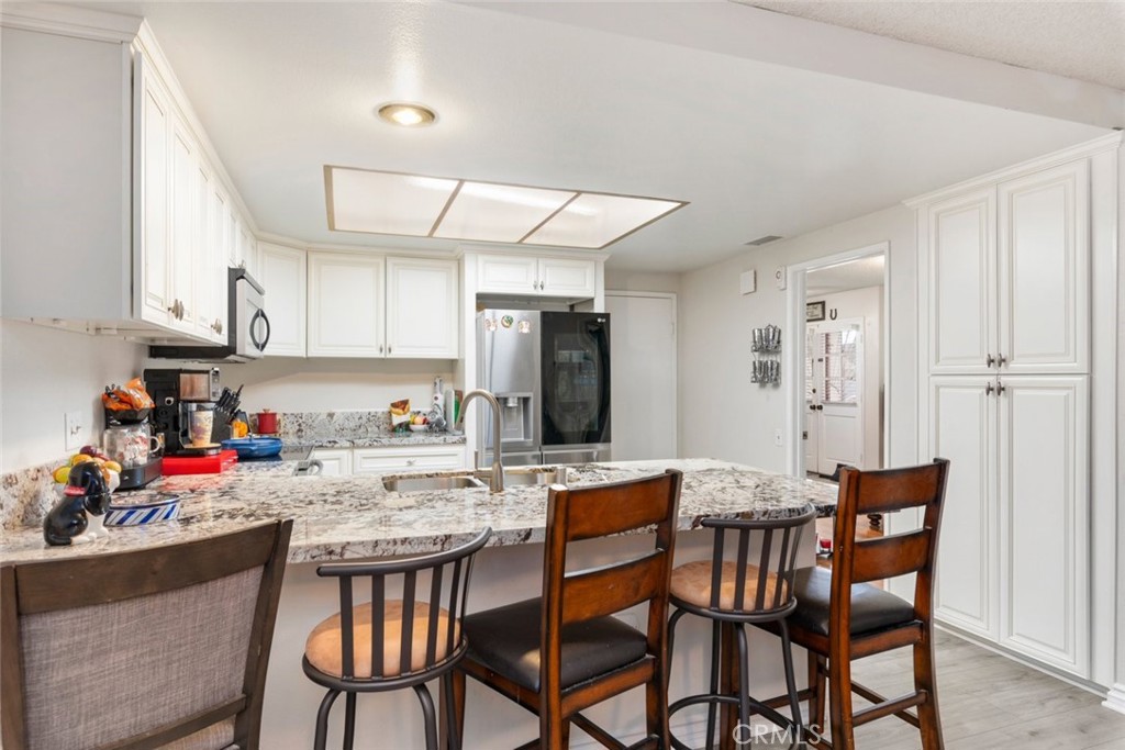 27262 Embassy Street Menifee, CA 92586 - Photo 17 of 35 a kitchen with a dining table chairs and refrigerator