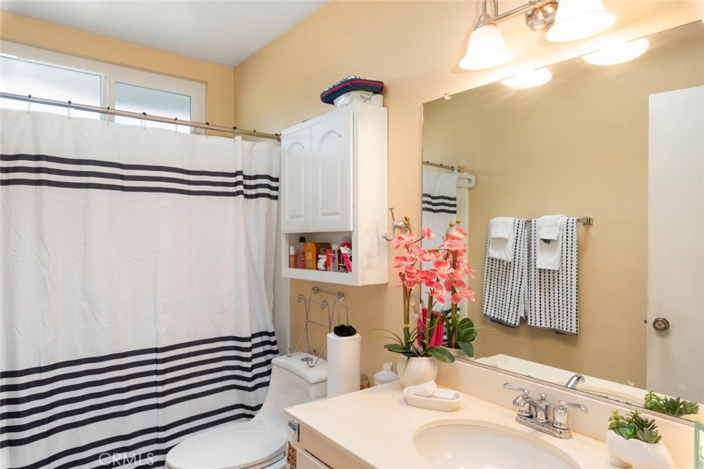 27262 Embassy Street Menifee, CA 92586 - Photo 24 of 35 a bathroom with a sink a mirror and a shower curtain