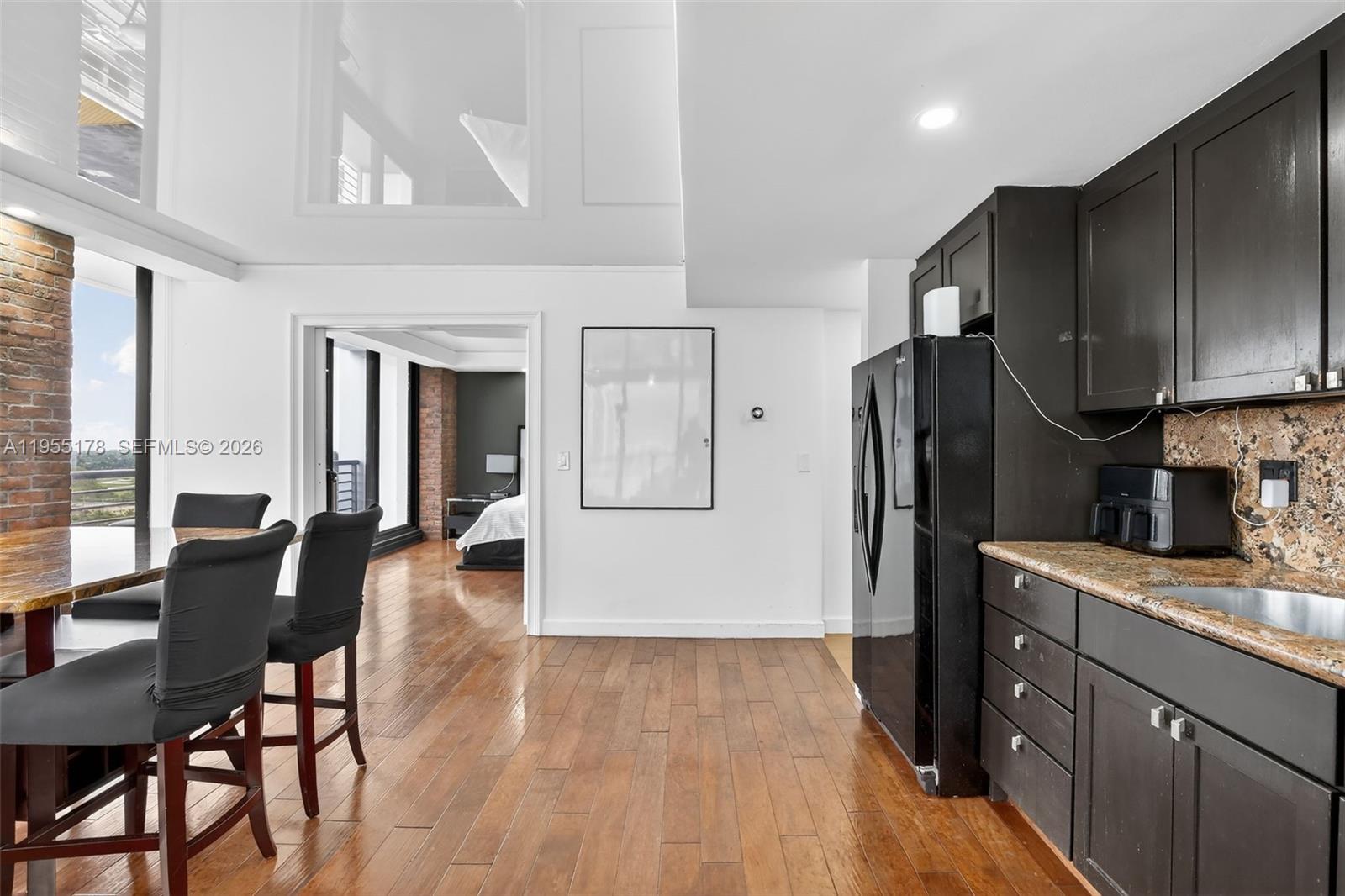 1720 Harrison Street, Unit 14H Hollywood, FL 33020 - Photo 11 of 37 a kitchen with stainless steel appliances granite countertop a refrigerator a sink dishwasher a stove with chairs and wooden floor