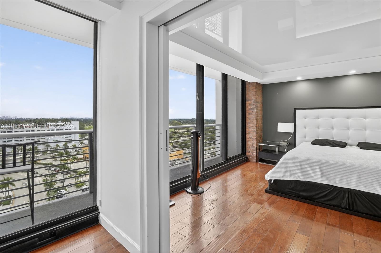 1720 Harrison Street, Unit 14H Hollywood, FL 33020 - Photo 18 of 37 a spacious bedroom with a bed and glass door