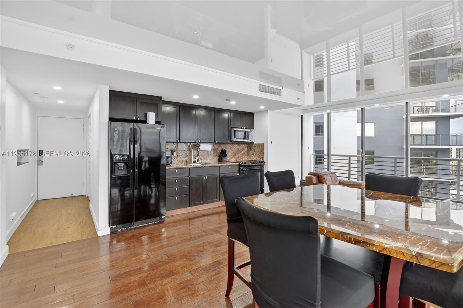 1720 Harrison Street, Unit 14H Hollywood, FL 33020 - Photo 3 of 37 a dining hall with stainless steel appliances kitchen island granite countertop a dining table and chairs