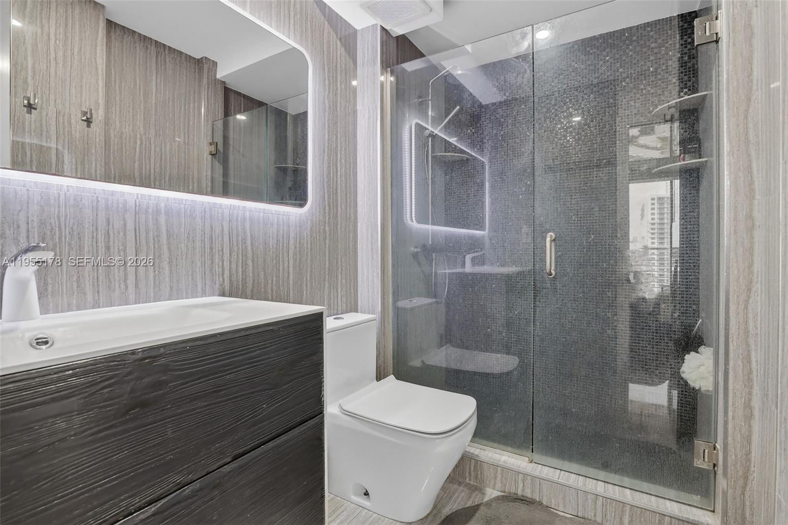 1720 Harrison Street, Unit 14H Hollywood, FL 33020 - Photo 5 of 37 a bathroom with a sink a toilet and shower