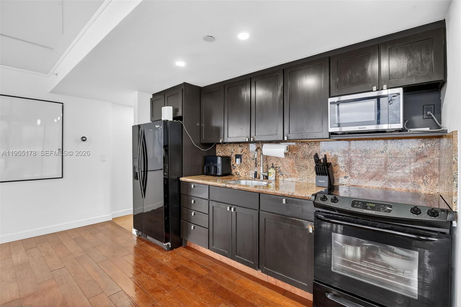 1720 Harrison Street, Unit 14H Hollywood, FL 33020 - Photo 9 of 37 a kitchen with granite countertop stainless steel appliances and wooden cabinets