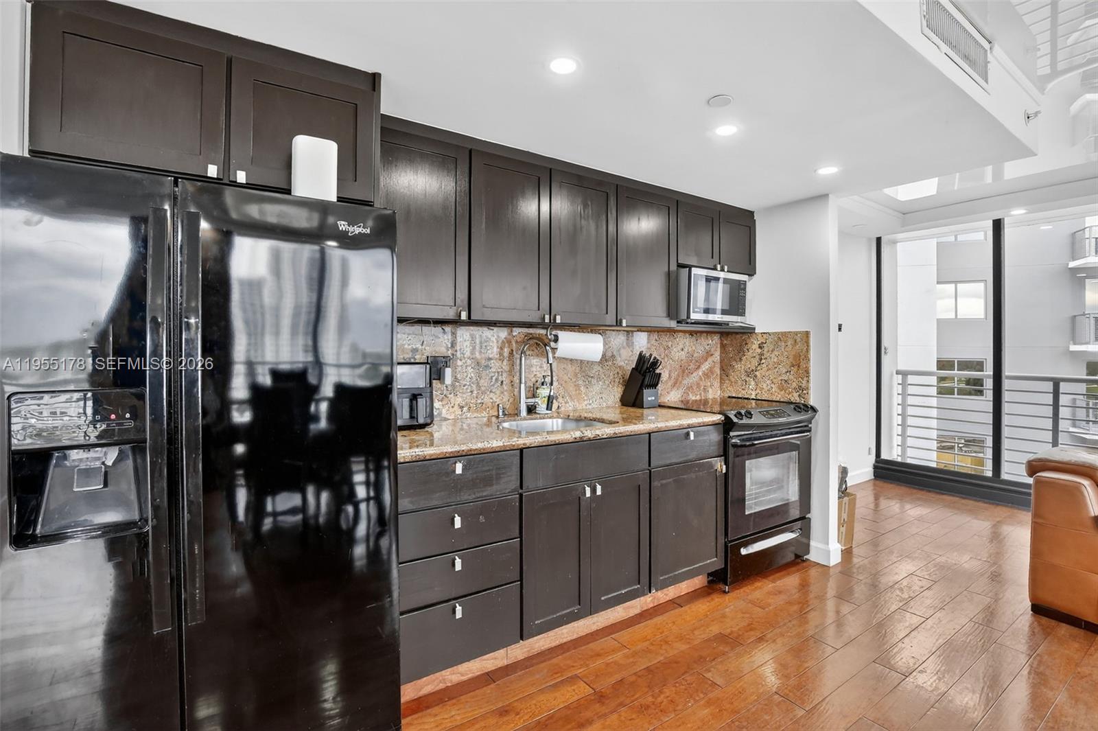 1720 Harrison Street, Unit 14H Hollywood, FL 33020 - Photo 10 of 37 a kitchen with granite countertop a refrigerator and cabinets