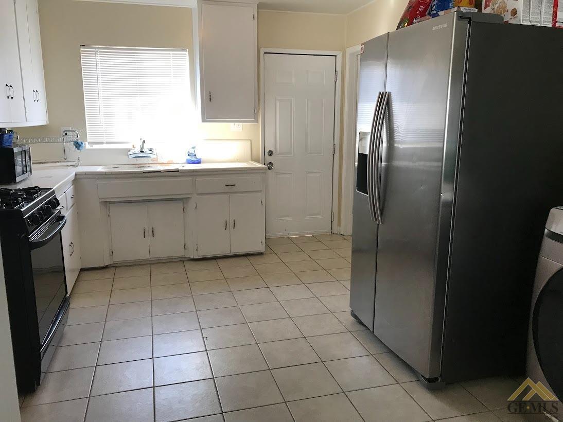 Undisclosed Address Bakersfield, CA 93305 - Photo 4 of 8 a kitchen with a sink a refrigerator and cabinets