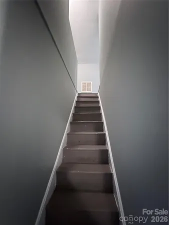 a view of an empty room with wooden floor and window