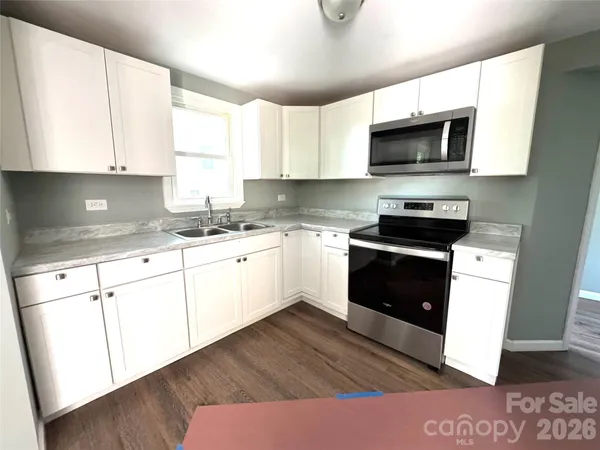 a kitchen with stainless steel appliances granite countertop a refrigerator sink stove microwave and cabinets