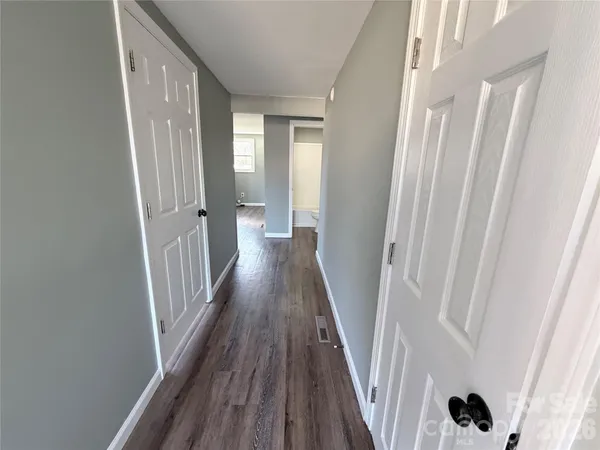 a view of a hallway with wooden floor and staircase