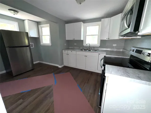 a kitchen with stainless steel appliances granite countertop a refrigerator sink stove microwave and cabinets