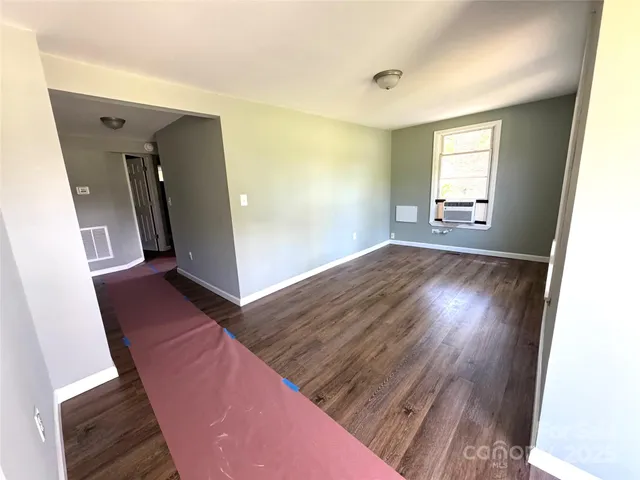 a view of a hallway with wooden floor and stairs