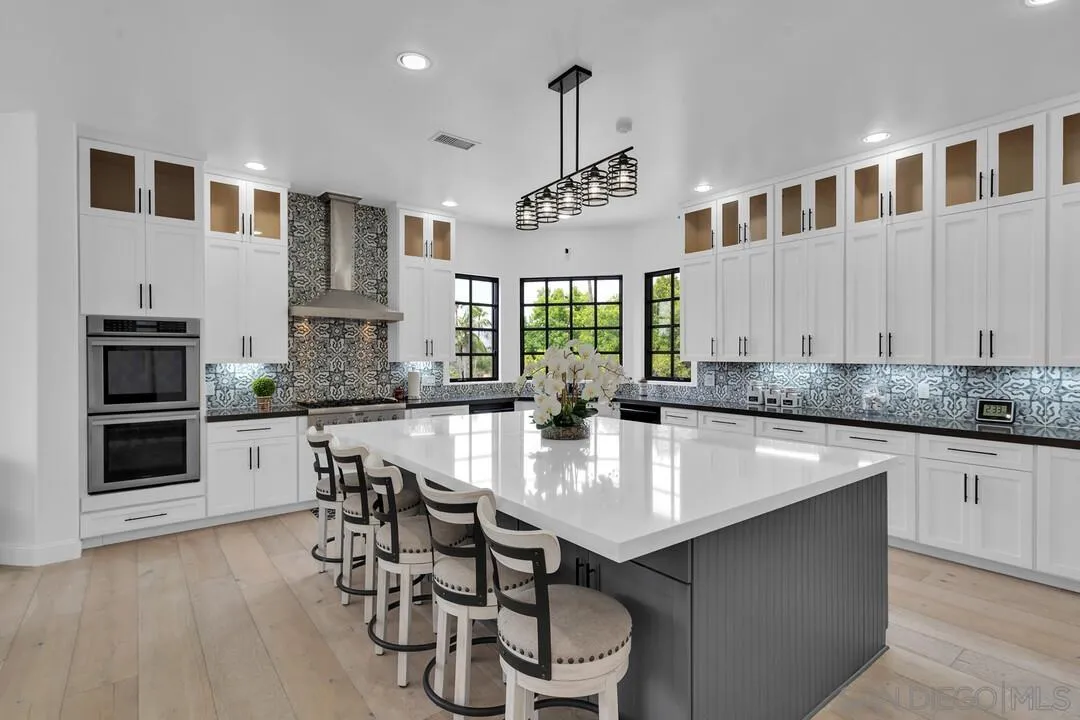 17101 Circa Oriente Rancho Santa Fe, CA 92067 - Photo 2 of 35 a kitchen with a dining table chairs stainless steel appliances and cabinets