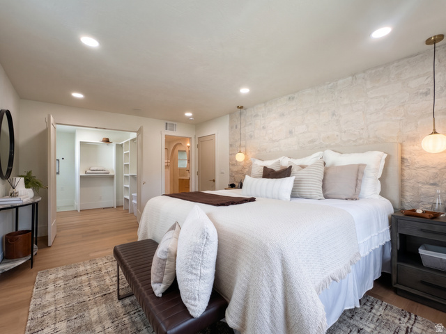1860 Spring Lane Holladay, UT 84117 - Photo 14 of 32 Recessed lighting illuminates the room, featuring a stone accent wall and wood-finish flooring