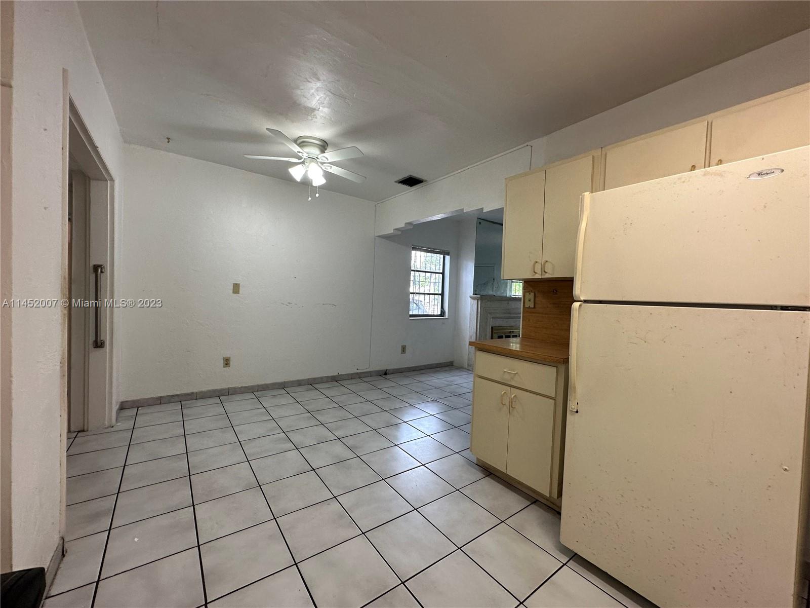 West Flagler Miami, FL 33135 - Photo 19 of 46 a kitchen with a refrigerator a stove top oven and cabinets