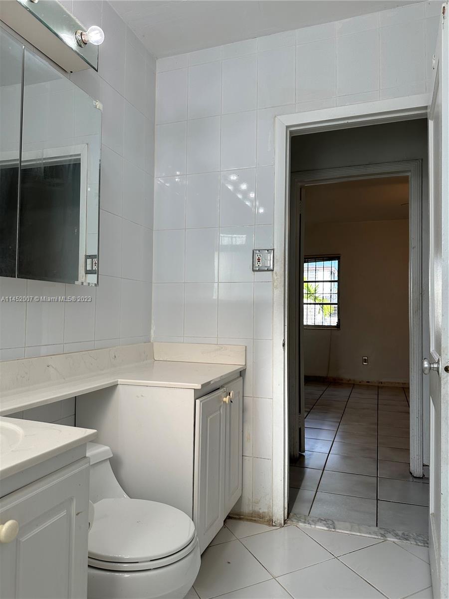 West Flagler Miami, FL 33135 - Photo 36 of 46 a bathroom with a toilet sink and mirror