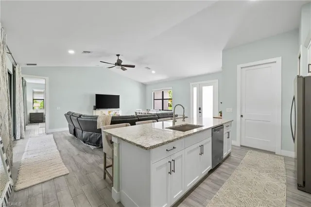 a view of living room kitchen with a sink and refrigerator