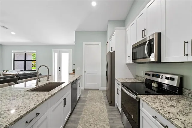 a kitchen with granite countertop a sink and stainless steel appliances