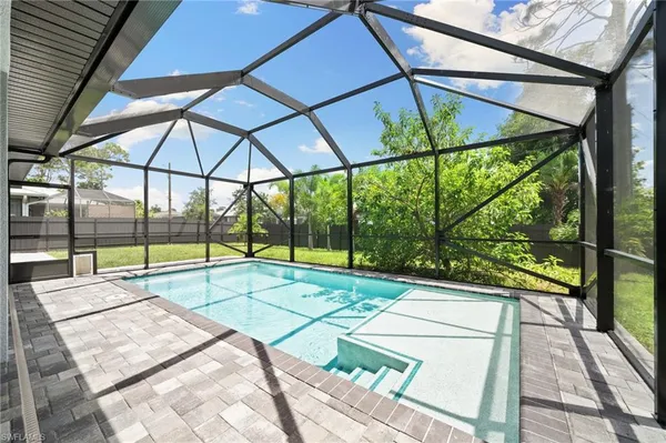 a view of a patio with a table and chairs under an umbrella