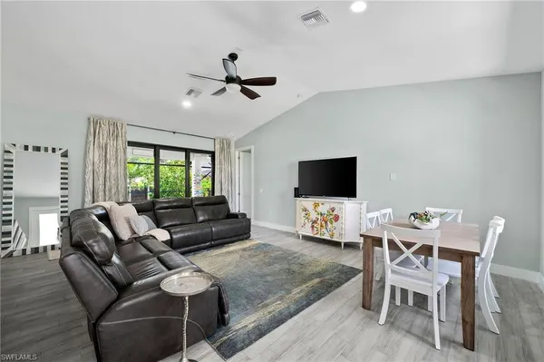a living room with furniture a flat screen tv and a window