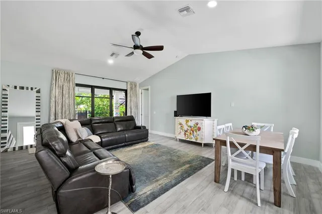a living room with furniture a flat screen tv and a window