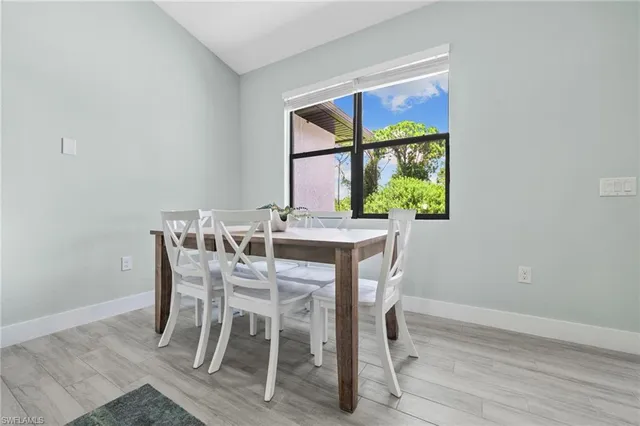 a view of a dining room with furniture a potted plant and wooden floor