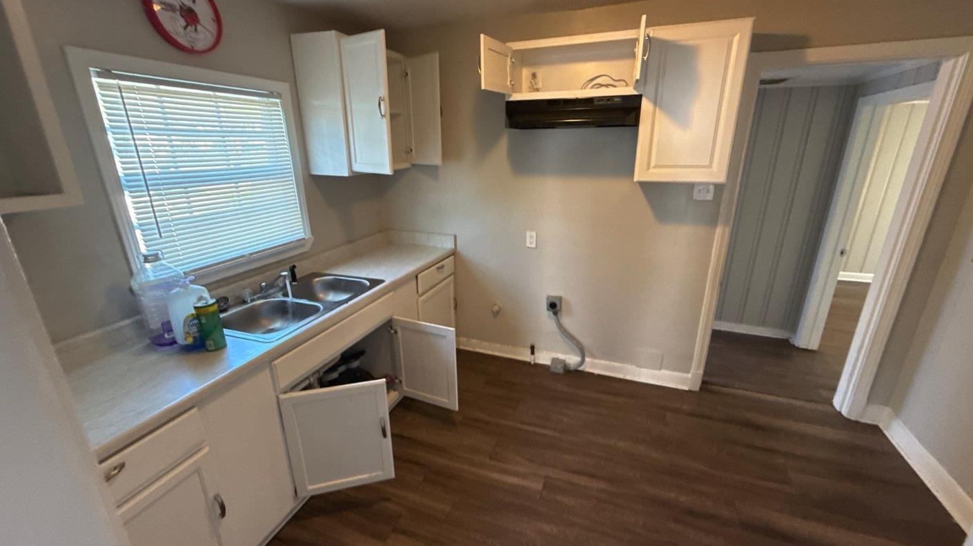 1311 Marlin Road Memphis, TN 38116 - Photo 2 of 4 Kitchen featuring light countertops, white cabinetry, and dark wood finished floors