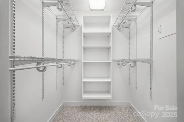 a view of walk in closet with empty racks