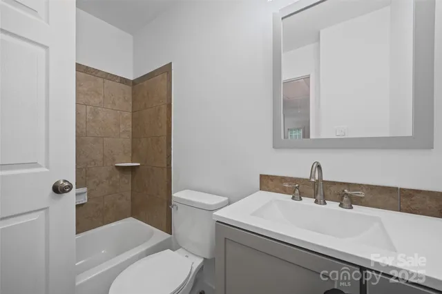 a bathroom with a sink toilet vanity and shower