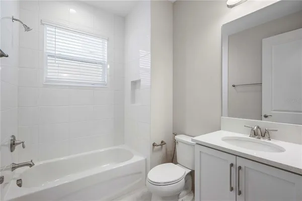 a bathroom with a granite countertop toilet a sink and a bathtub