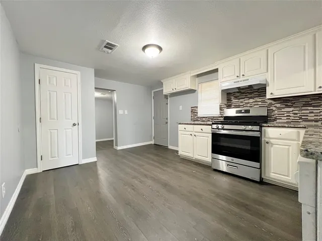 a kitchen with wooden floors and white appliances