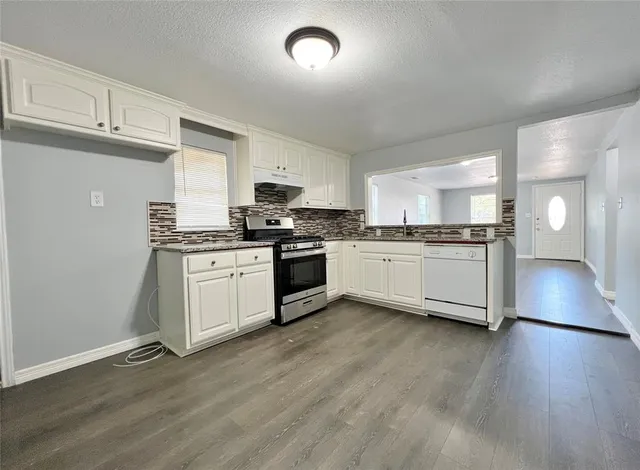 a kitchen with stainless steel appliances a stove top oven and cabinets