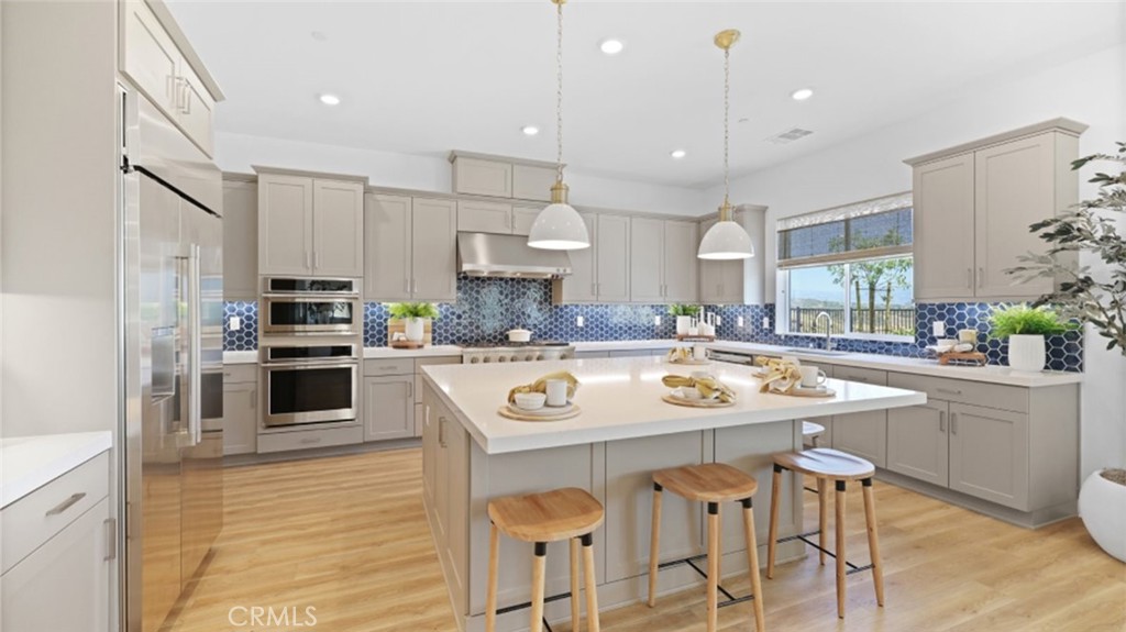 a kitchen with stainless steel appliances granite countertop a sink and a refrigerator