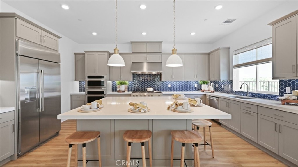 29602 Paseo Tranquilo Valencia, CA 91354 - Photo 2 of 43 a kitchen with a table a sink refrigerator and cabinets