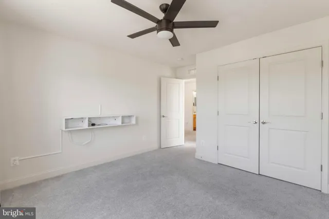 a house that is sitting in the grass with large trees