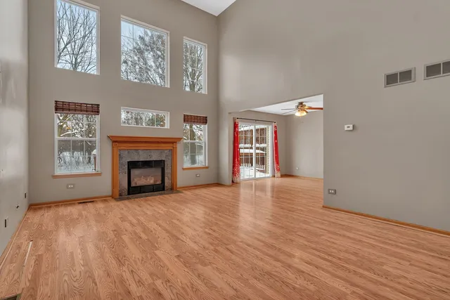 a view of empty room with wooden floor and fireplace