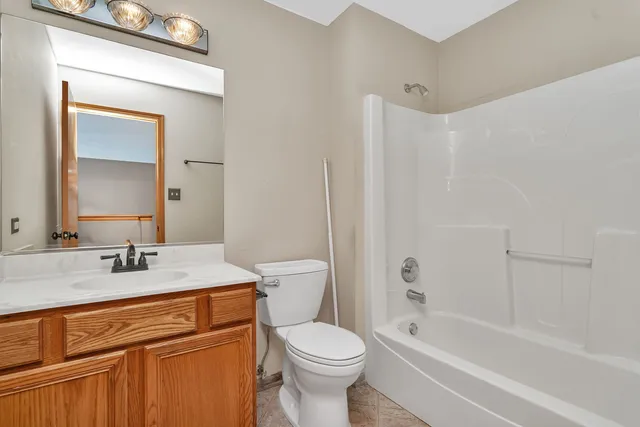 a bathroom with a sink toilet vanity and tub