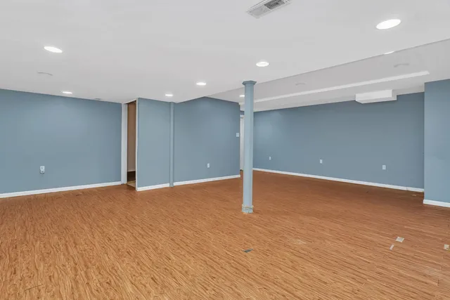 a view of an empty room with wooden floor
