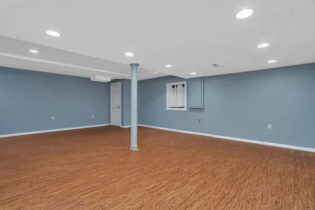 a view of an empty room with wooden floor and closet