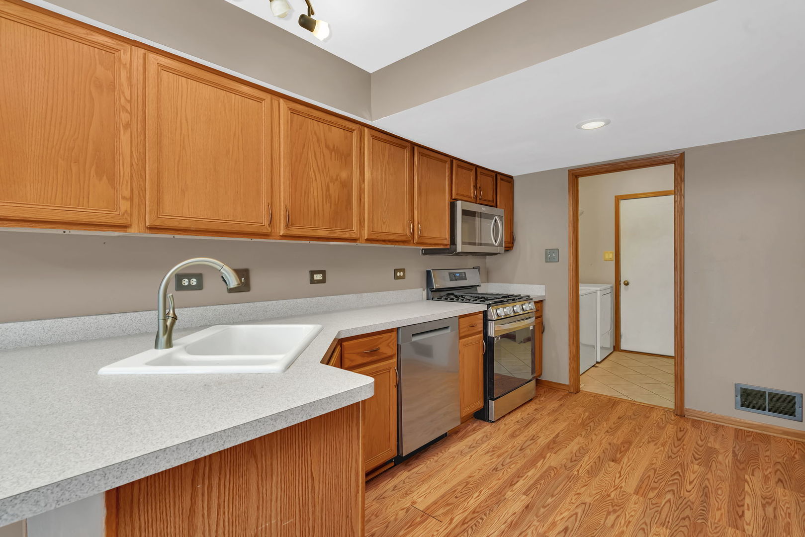 936 Treeline Court Lockport, IL 60441 - Photo 3 of 33 a kitchen with stainless steel appliances granite countertop a sink dishwasher stove and refrigerator with wooden floor