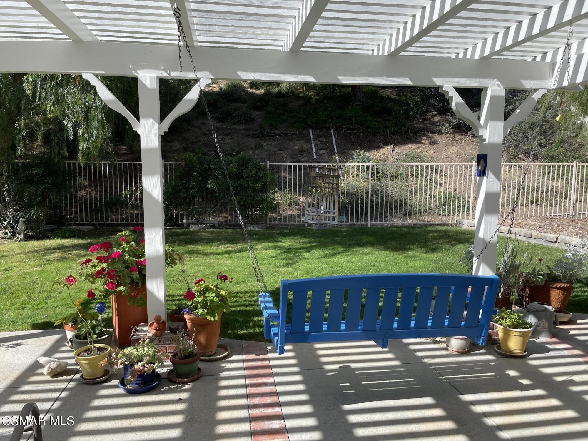 28587 Haskell Canyon Road Saugus, CA 91390 - Photo 23 of 26 a view of a patio with table and chairs potted plants and floor to ceiling window