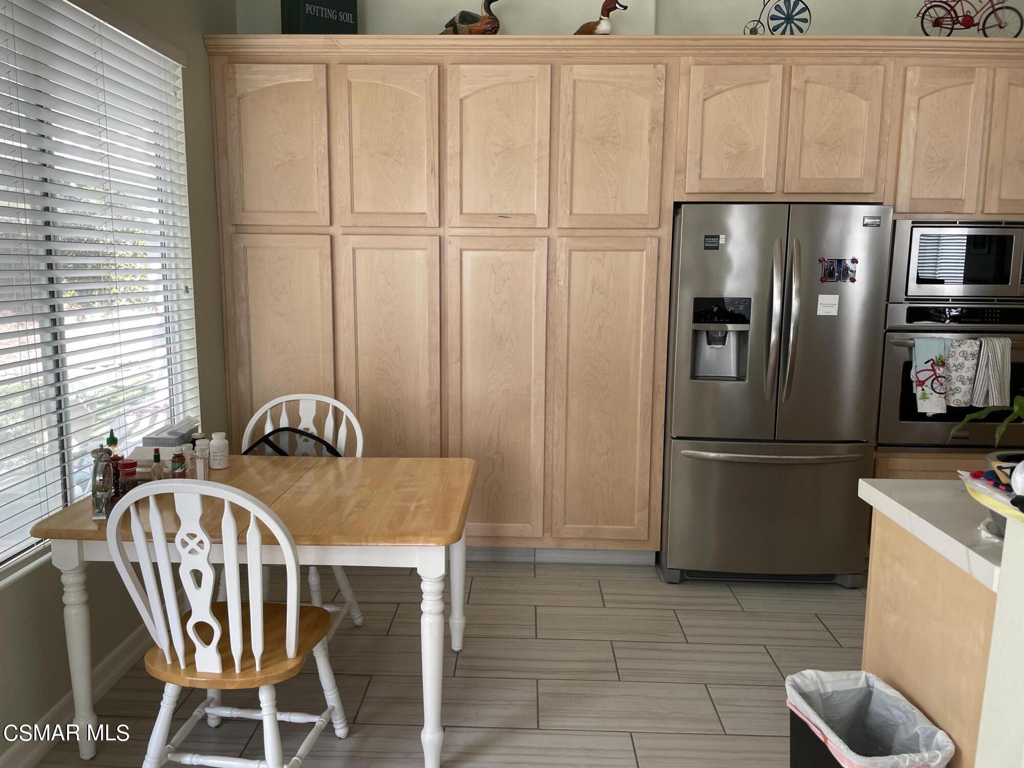 28587 Haskell Canyon Road Saugus, CA 91390 - Photo 8 of 26 a kitchen with stainless steel appliances a refrigerator a sink a table and chairs