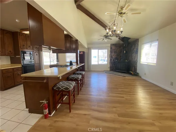 an open kitchen with granite countertop a stove a sink a dining table and chairs