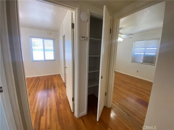 a view of a hallway with wooden floor and staircase