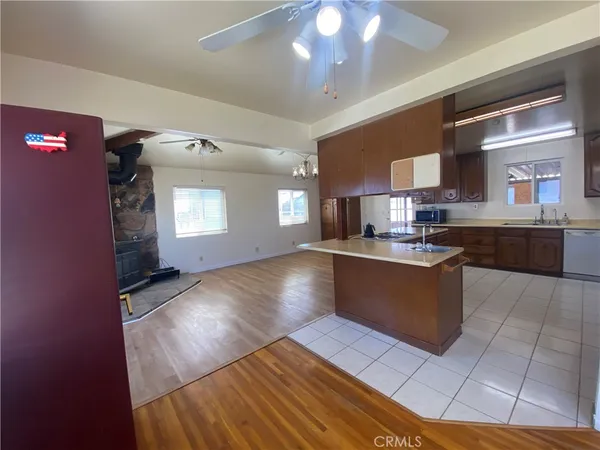 a kitchen with stainless steel appliances granite countertop a sink counter space cabinets and a fireplace