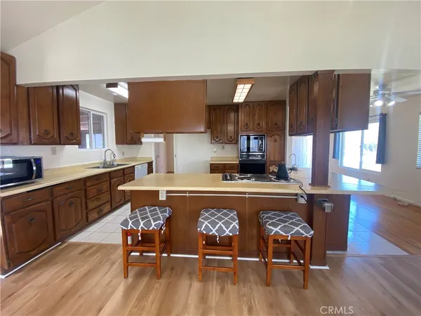 a kitchen with a table chairs refrigerator and wooden cabinets