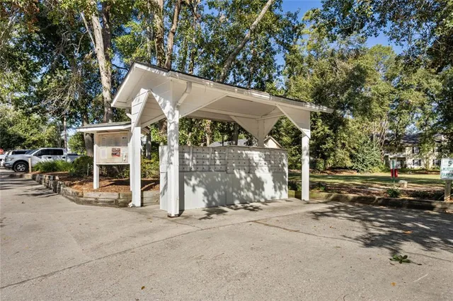 a view of a house with large trees and wooden fence