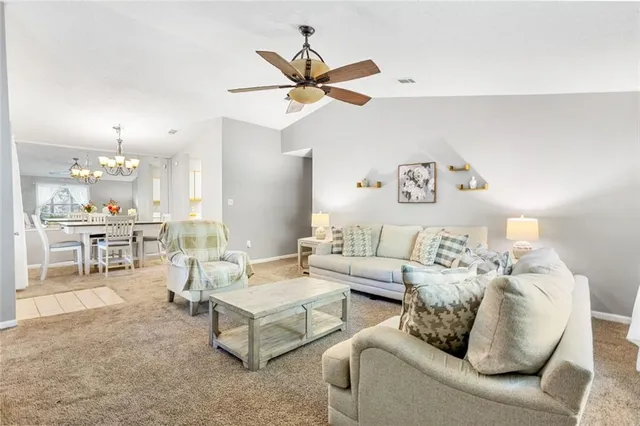 a living room with furniture and a view of kitchen