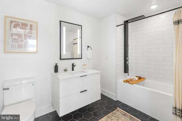 a bathroom with a tub sink and mirror