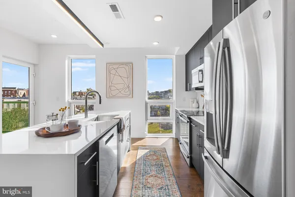 a kitchen with stainless steel appliances a refrigerator and a stove top oven