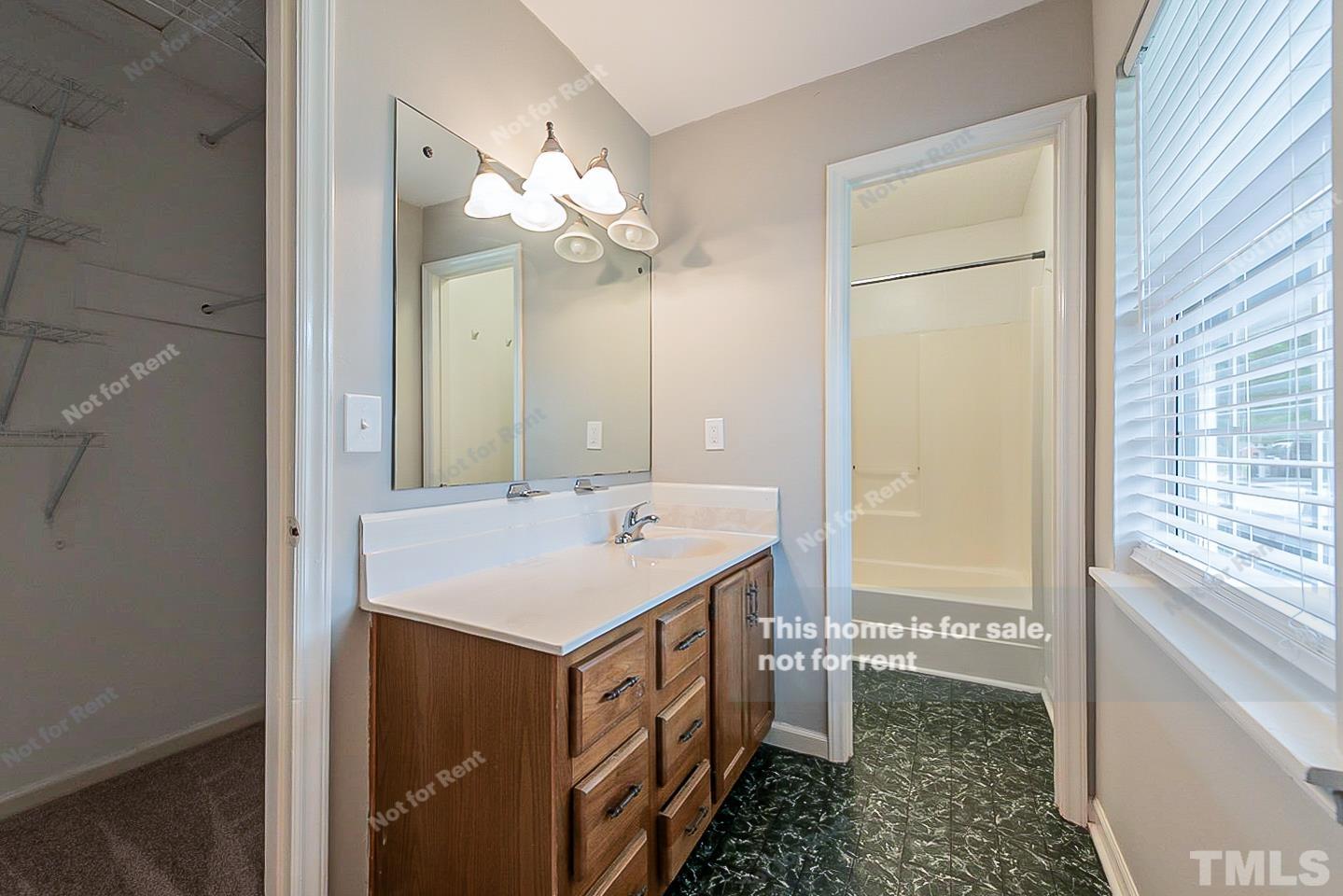 917 Horton Road Durham, NC 27704 - Photo 4 of 17 a bathroom with a sink a mirror and a bathtub