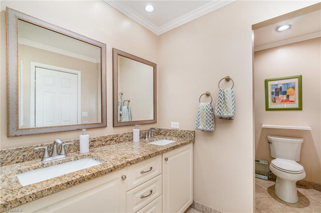 1933 Countess Court Naples, FL 34110 - Photo 15 of 25 a bathroom with a granite countertop toilet sink and mirror